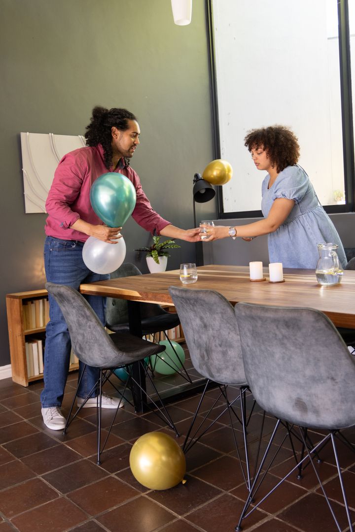 Couple Decorating Modern Dining Room with Metallic Balloons