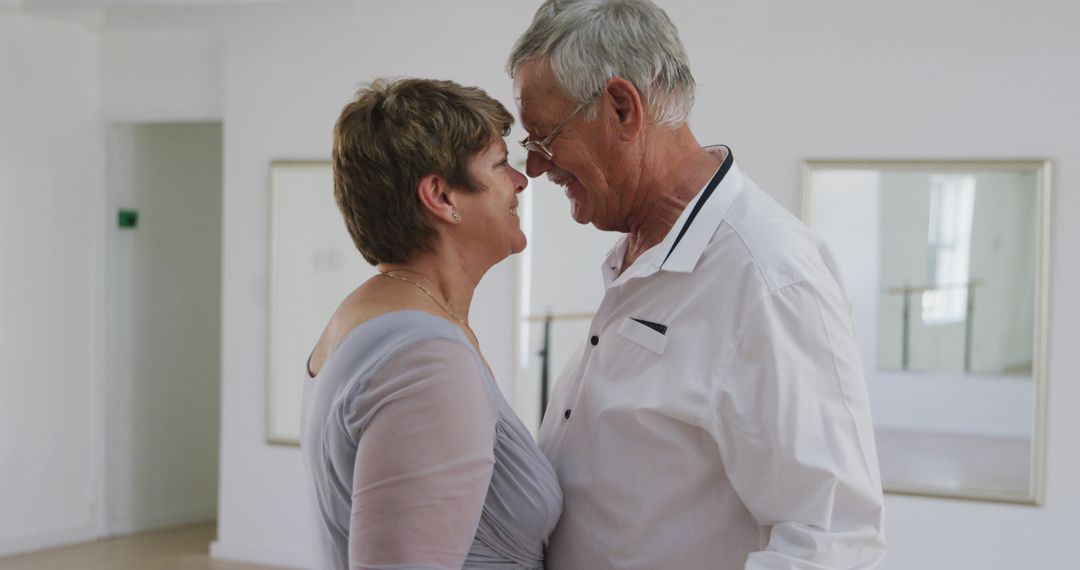 Elderly Couple Embracing and Smiling Together Indoors - Free Images, Stock Photos and Pictures on Pikwizard.com