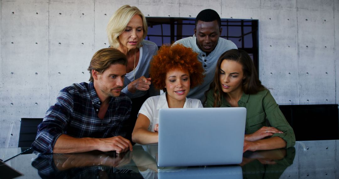 Diverse Team Collaborates on Laptop in Modern Office Setting