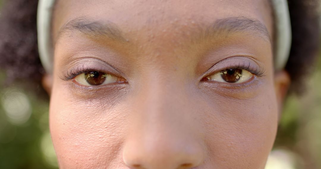 Eyes closeup of african american woman standing in sunny garden - Free Images, Stock Photos and Pictures on Pikwizard.com