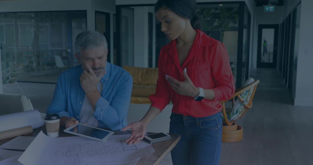 Architects Reviewing Blueprints in Contemporary Office with Tablet