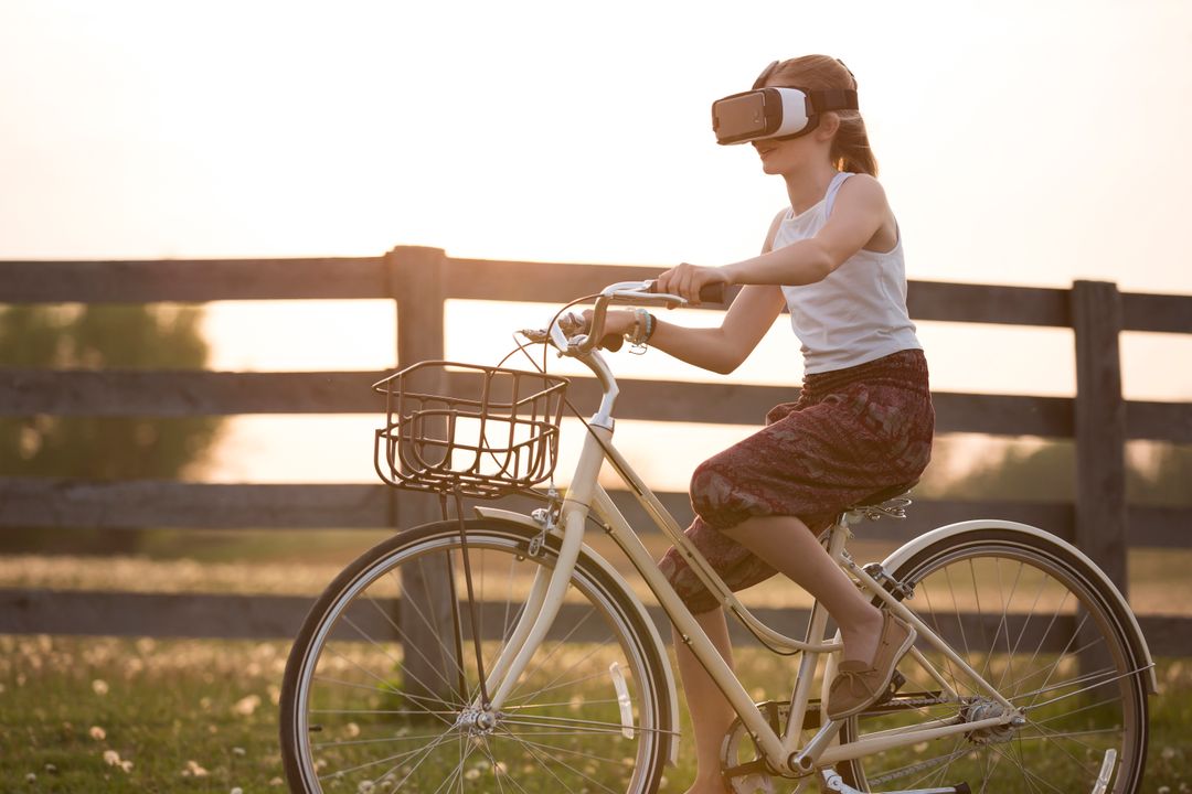 Girl Wearing Vr Box Driving Bicycle during Golden Hour - Free Images, Stock Photos and Pictures on Pikwizard.com