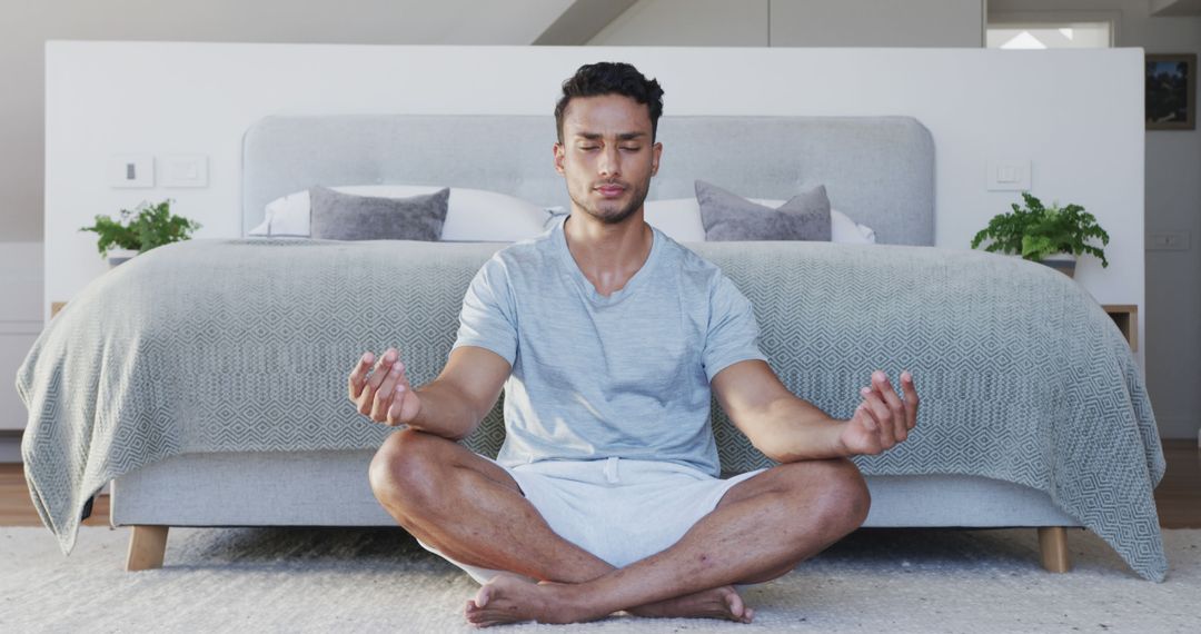 Man Practicing Meditative Yoga in Modern Bedroom - Free Images, Stock Photos and Pictures on Pikwizard.com