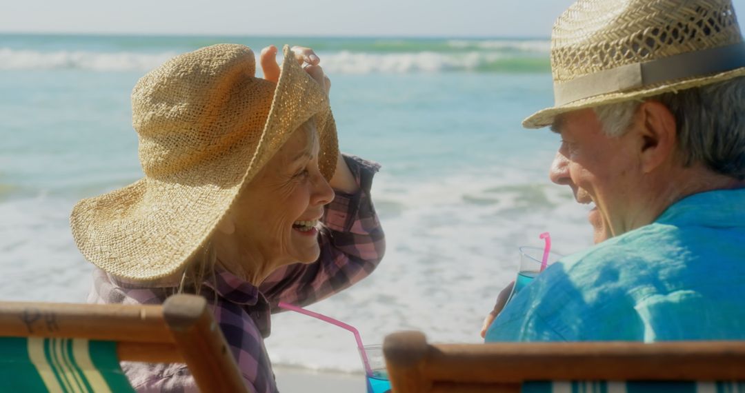 Senior Couple Enjoying Refreshing Drinks by Ocean
