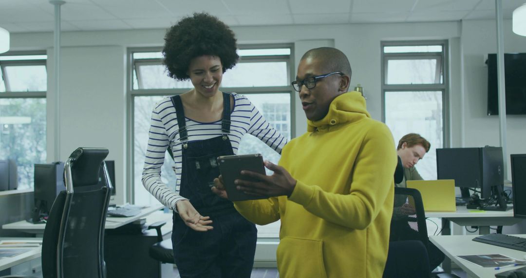Two Colleagues Collaborating on Digital Content in Modern Office