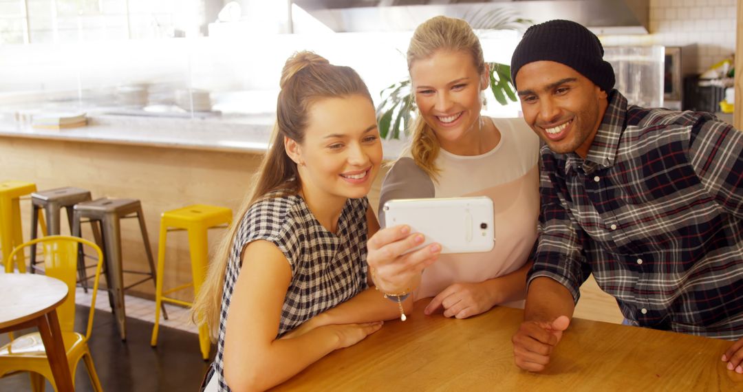 Diverse Friends Smiling While Taking Selfie in Bright Cafe