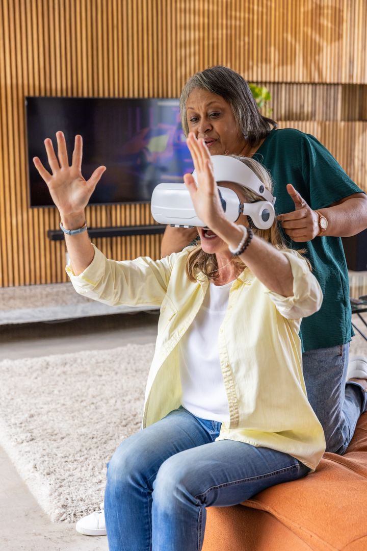 Diverse Senior Females Experiencing Virtual Reality in Modern Living Space