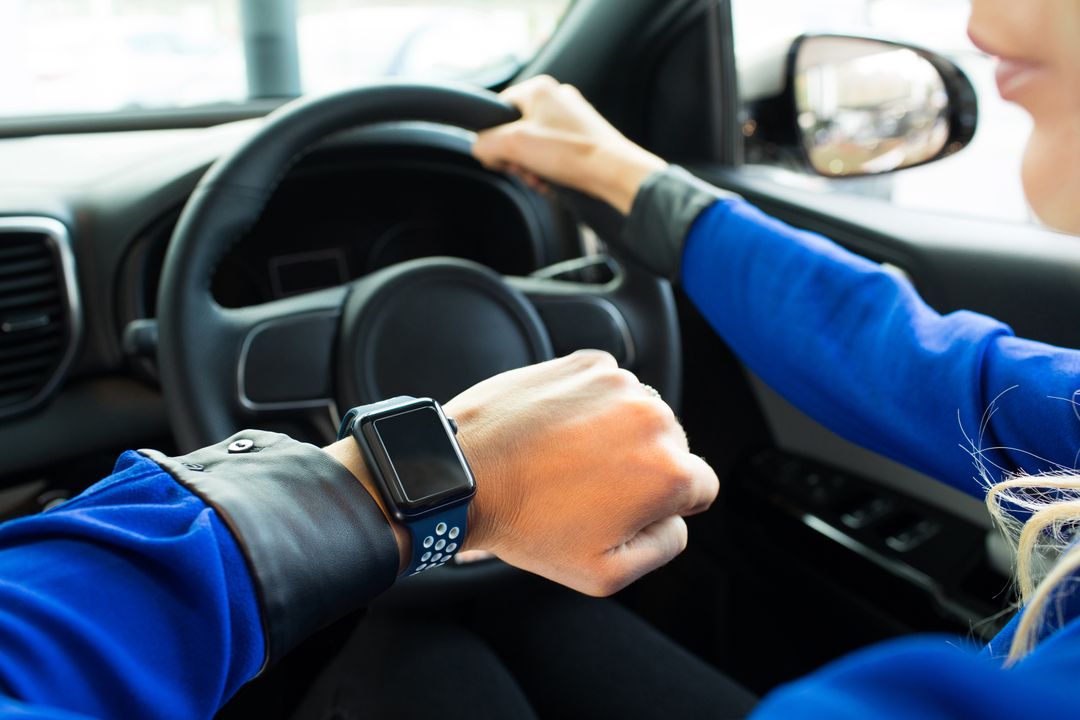 Cropped image of woman looking at smart watch during test drive - Free Images, Stock Photos and Pictures on Pikwizard.com