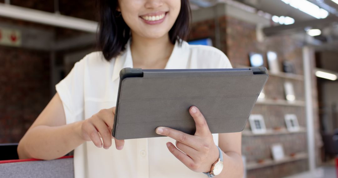 Asian Professional Using Tablet in Modern Open Office