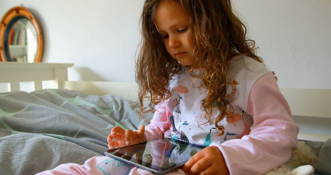 Young Girl Engaged with Tablet in Bedroom Setting - Free Images, Stock Photos and Pictures on Pikwizard.com