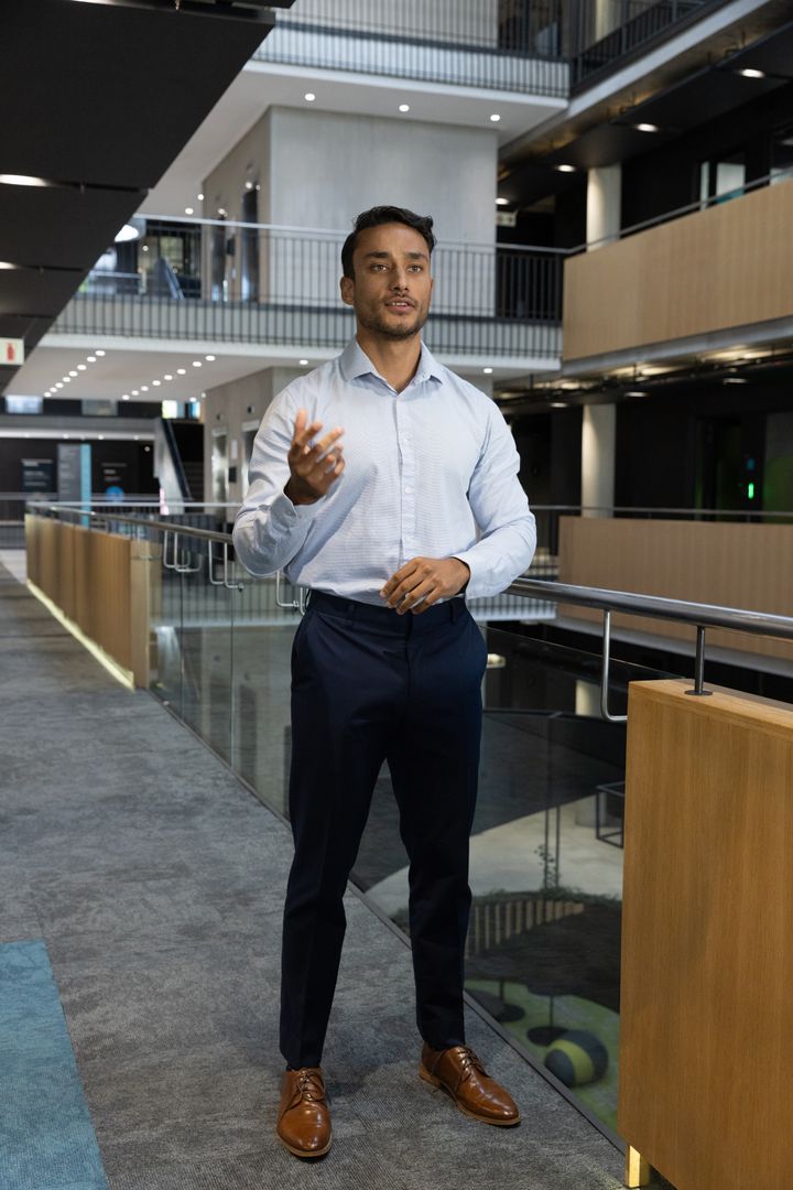 Confident Businessman Speaking in Corporate Atrium