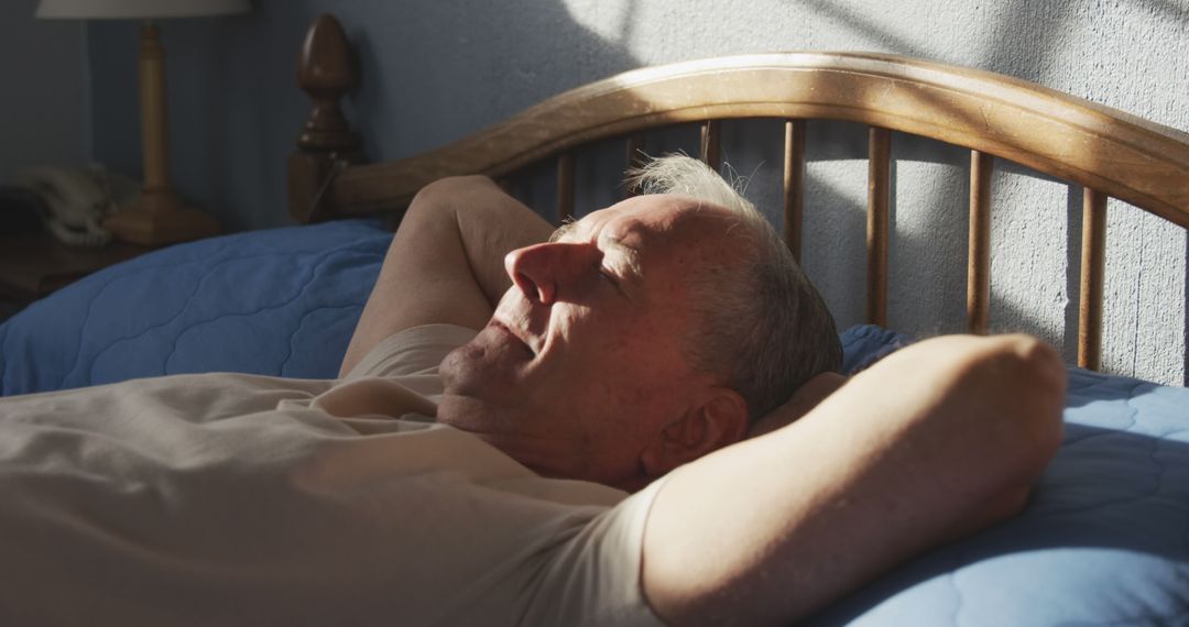 Senior Man Relaxing in Bed with Sunlight on Face in Warm Morning Light - Free Images, Stock Photos and Pictures on Pikwizard.com