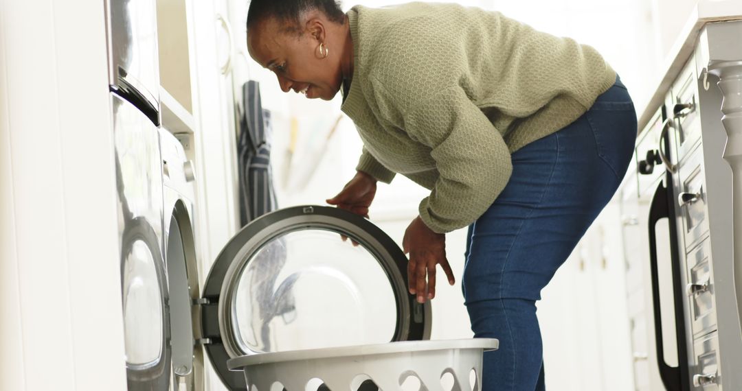 Woman Doing Laundry in Contemporary Kitchen - Free Images, Stock Photos and Pictures on Pikwizard.com