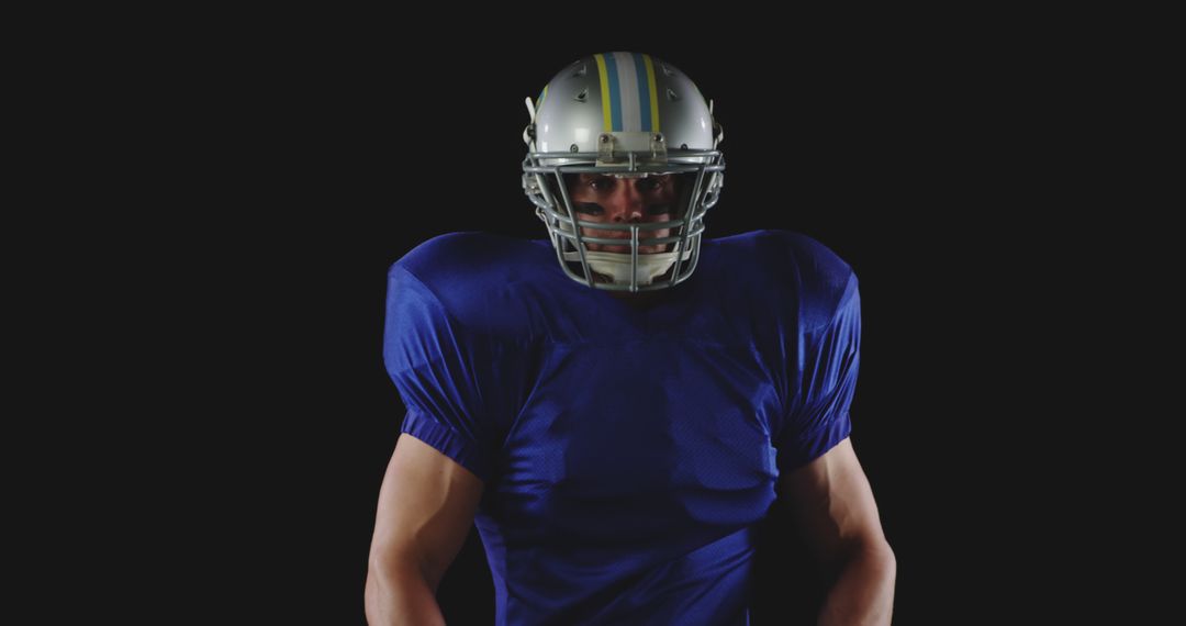 Confident American Football Player Posed in Uniform against Black Background - Free Images, Stock Photos and Pictures on Pikwizard.com