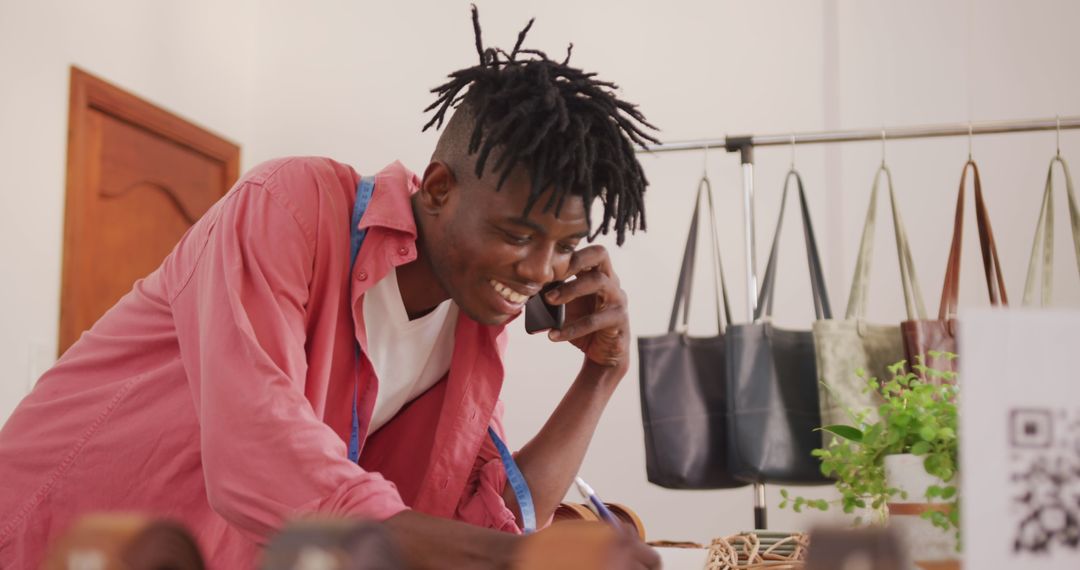 Young Craftsman Taking Phone Order in Leather Workshop