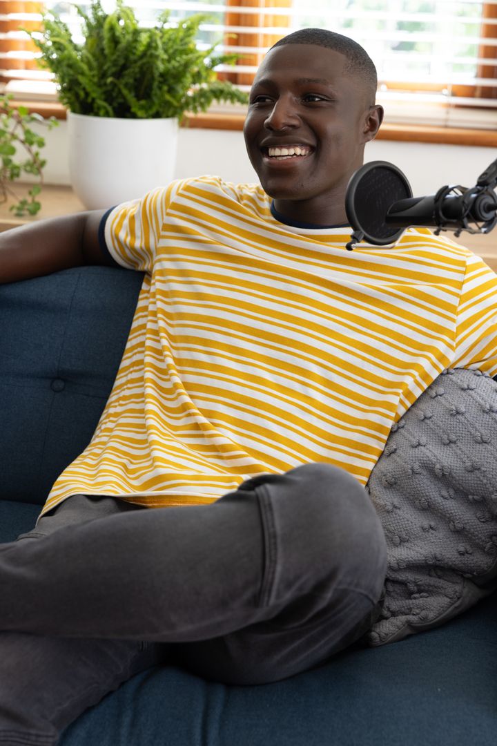 Smiling Podcaster Engaging Audience in Cozy Home Studio