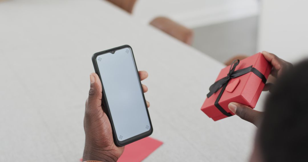 Man Holding Smartphone and Gift Box for Special Occasion Video Call
