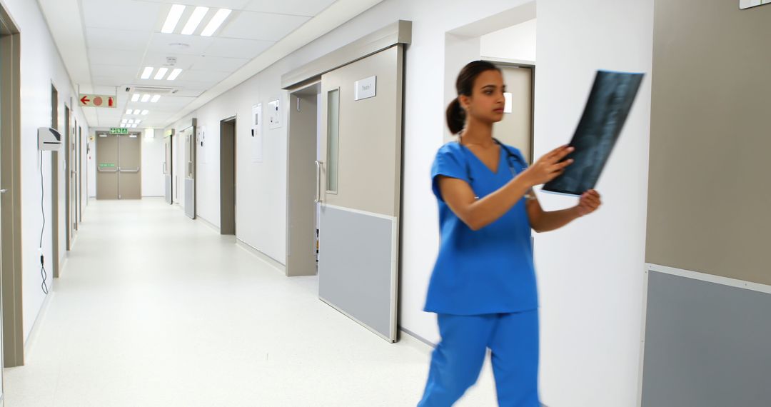 Medical Assistant Examining X-ray in Hospital Corridor - Free Images, Stock Photos and Pictures on Pikwizard.com