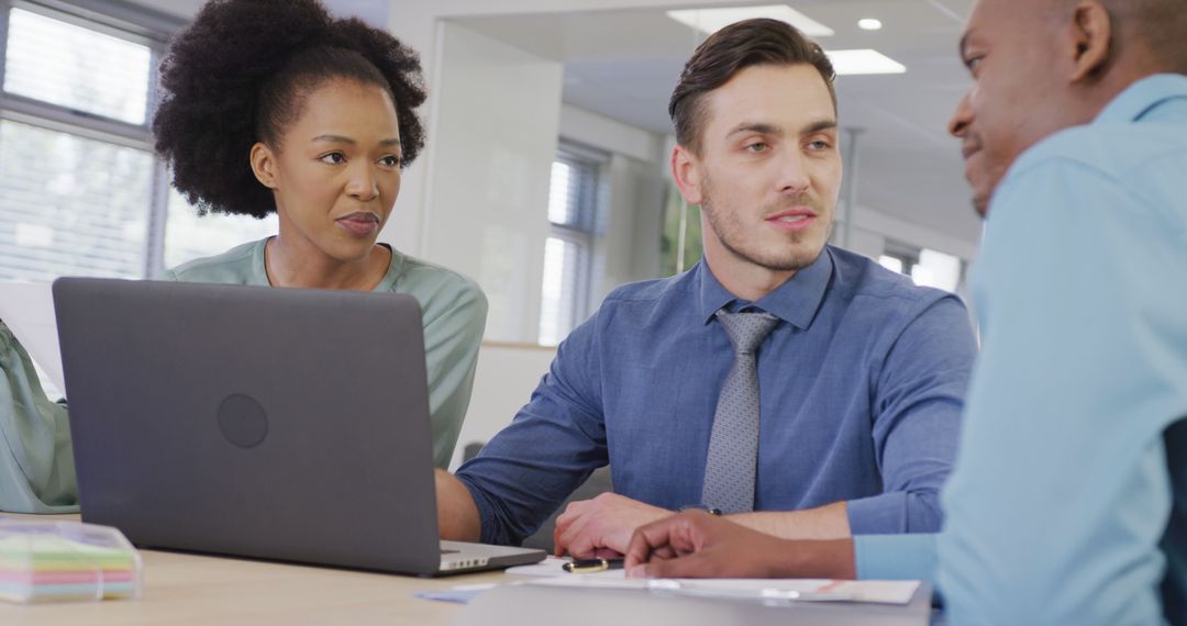 Diverse Team Collaborating with Laptop in Office Setting