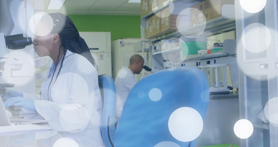 Technicians Utilizing Microscopes in Scientific Research Lab