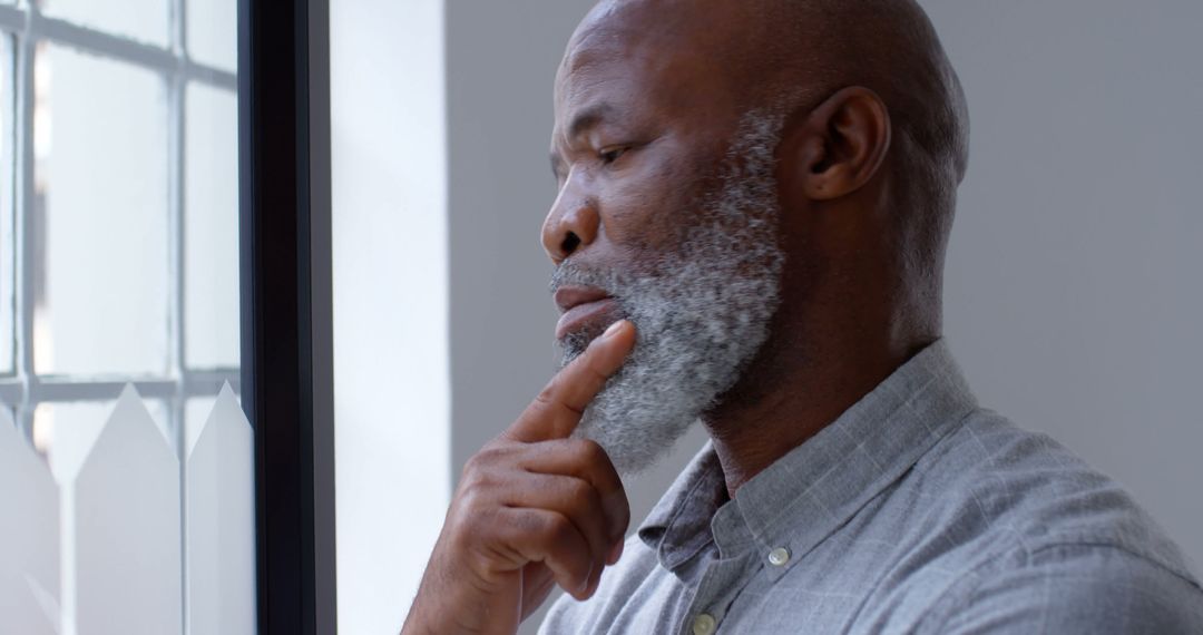 Pensive Elderly Man Standing by Window in Thought - Free Images, Stock Photos and Pictures on Pikwizard.com