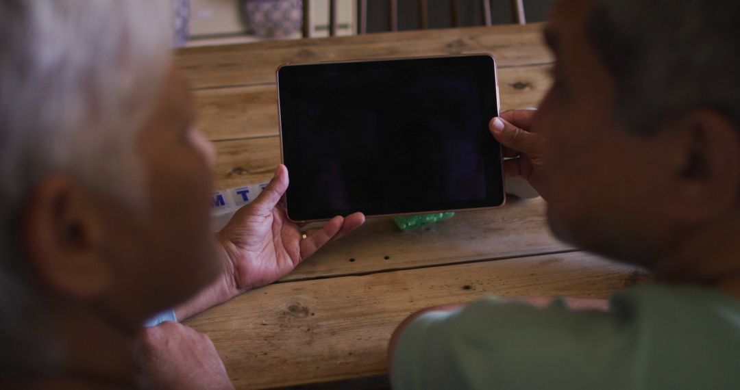 Senior Couple Using Tablet at Home Discussing Technology Together