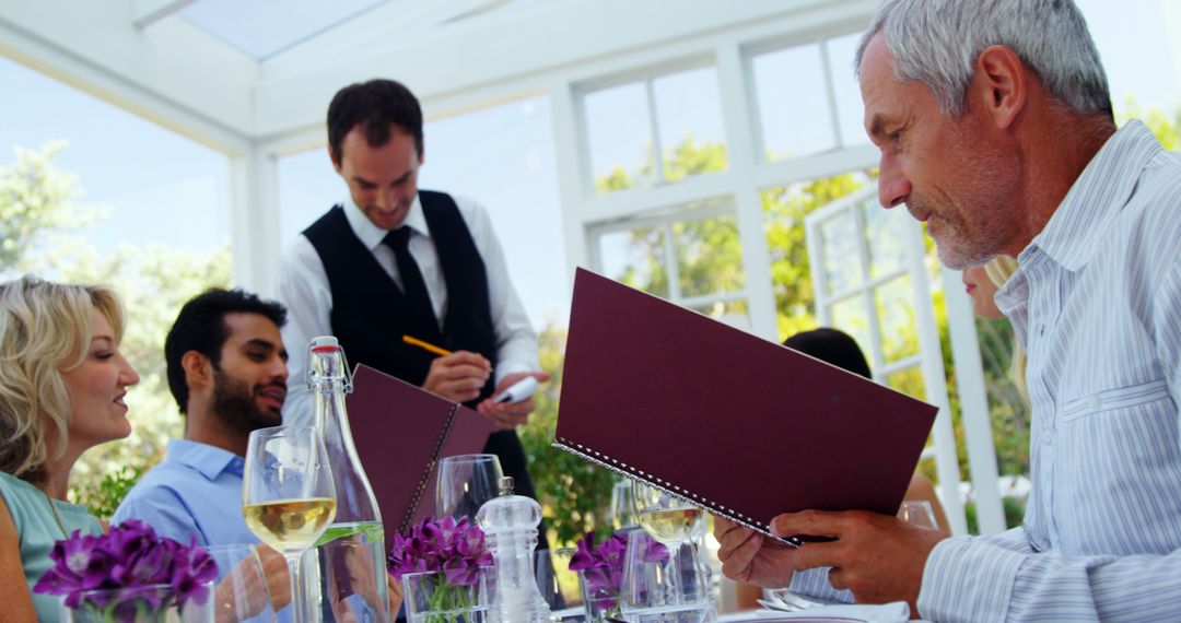 Diverse Group Dining with Waiter in Upscale Restaurant Setting