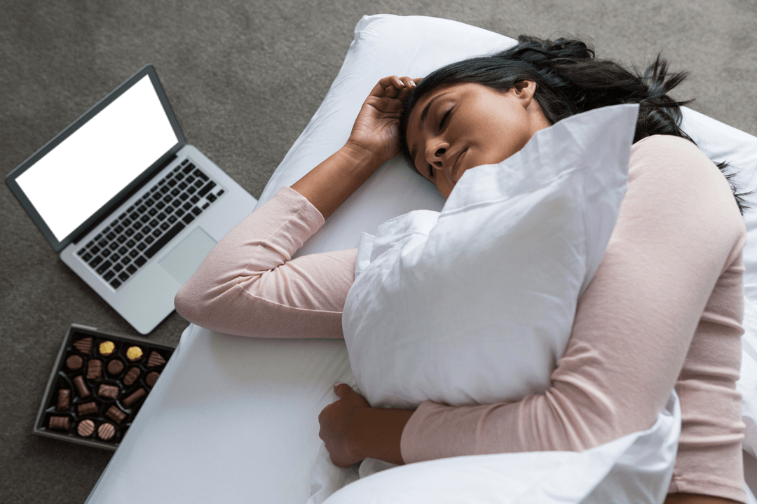 Young Woman Resting on Bed with Laptop Near Chocolate Box Displayed Transparent Regret