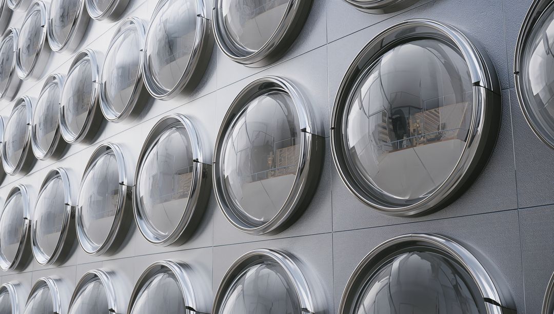 Hemispherical Glass Portholes Repeating on Metallic Building Facade with Chrome Bezels