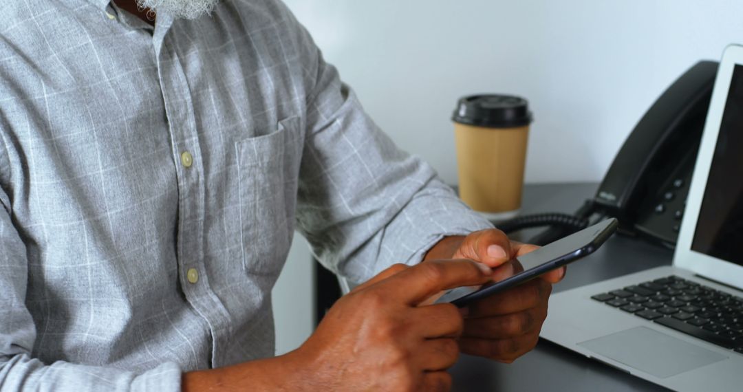 Businessman Engaged with Smartphone at Office Desk