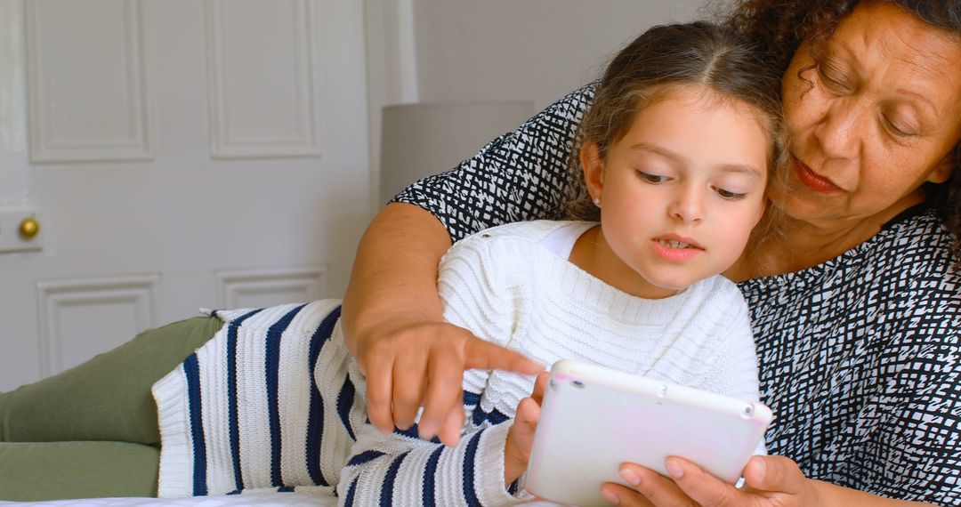 Grandmother and Granddaughter Using Digital Tablet on Bed - Free Images, Stock Photos and Pictures on Pikwizard.com