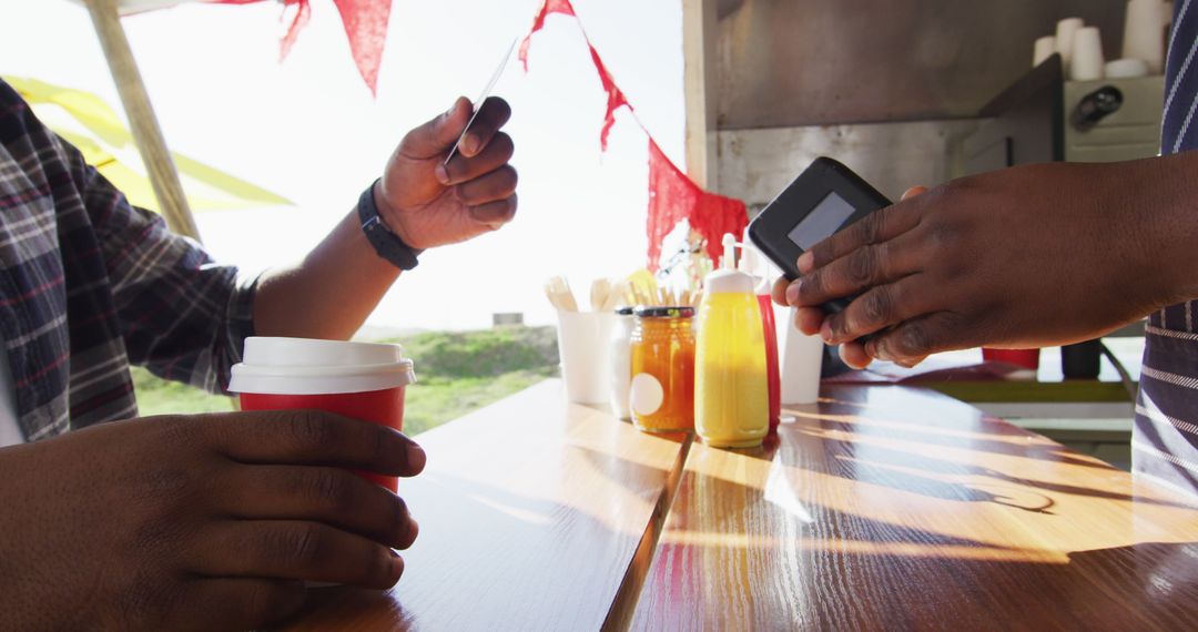 Customer using contactless payment at outdoor food vendor - Free Images, Stock Photos and Pictures on Pikwizard.com