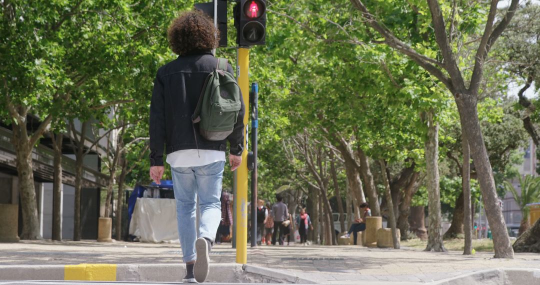 Man Walking in Tree-Lined City Street