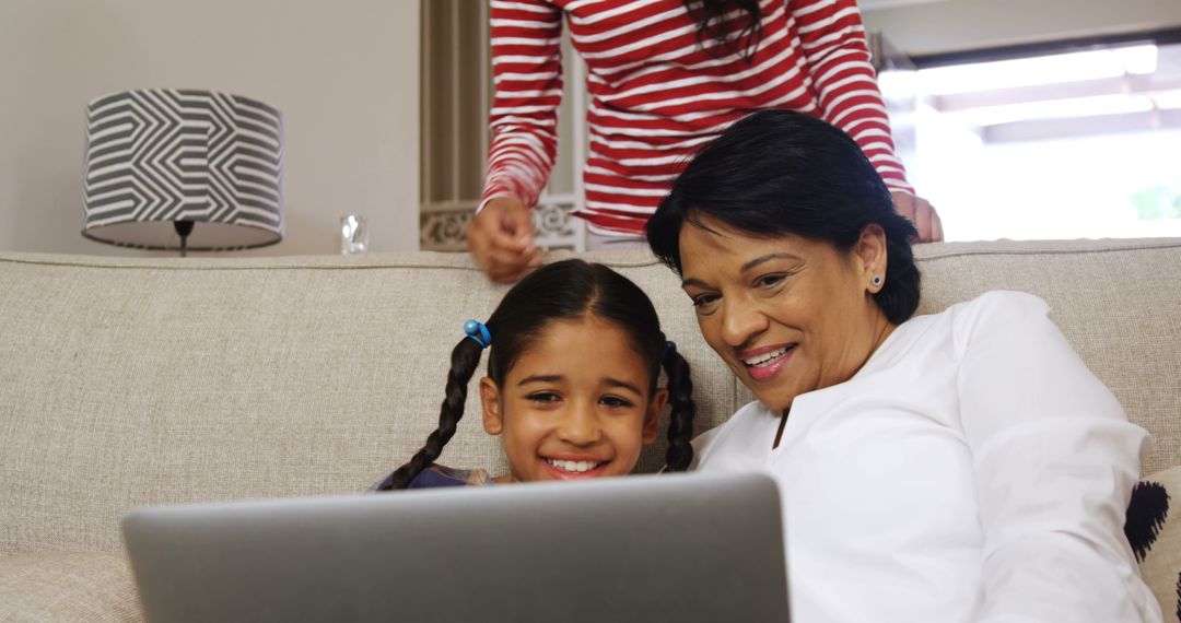 Grandmother and granddaughter using laptop on couch - Free Images, Stock Photos and Pictures on Pikwizard.com