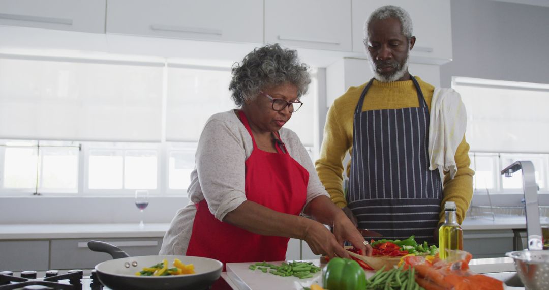 Senior African American Couple Cooking in Kitchen During Quarantine - Free Images, Stock Photos and Pictures on Pikwizard.com