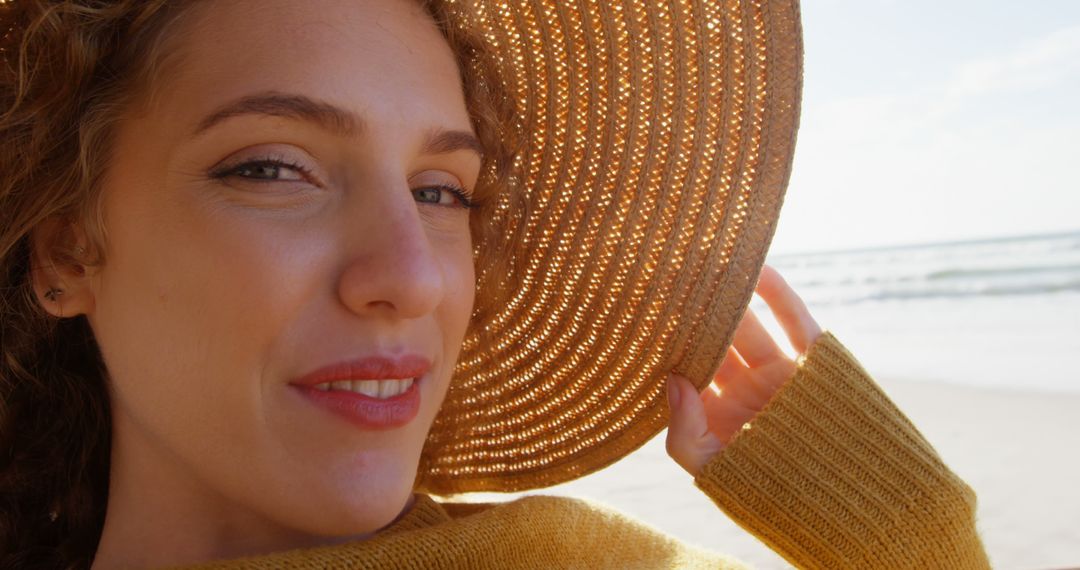 Smiling Woman Wearing Straw Hat Enjoying Sunny Beach Day - Free Images, Stock Photos and Pictures on Pikwizard.com