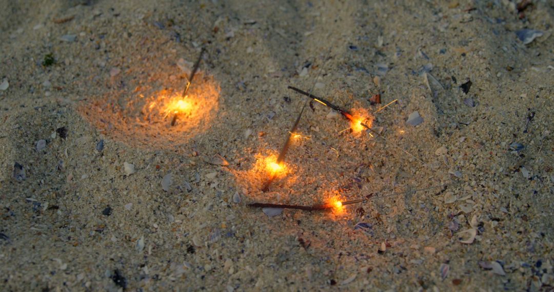 High angle view of sparklers on sand at beach - Free Images, Stock Photos and Pictures on Pikwizard.com