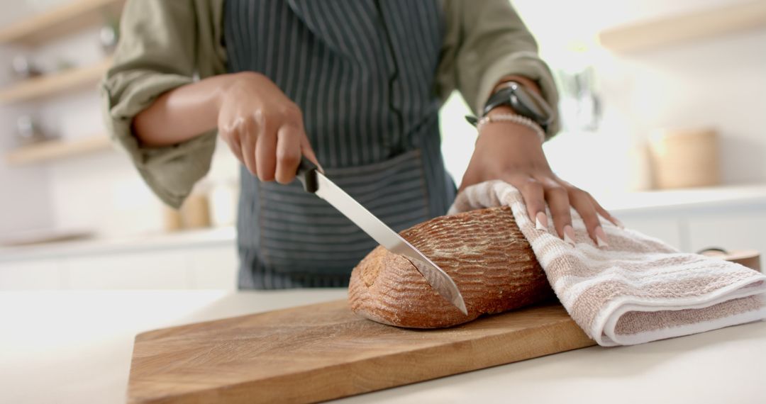 African American Woman Slicing Artisan Bread in Modern Kitchen