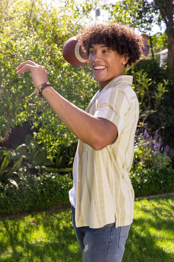 Man Enjoys Throwing Football Outdoors in Sunny Garden