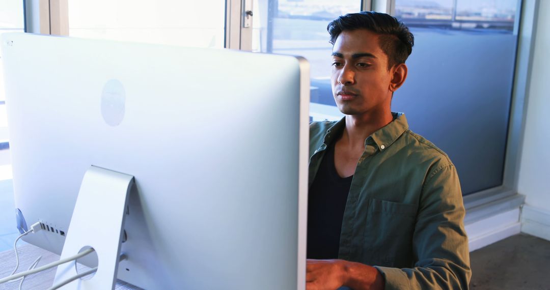 Focused Professional Working on Computer in Modern Office Space