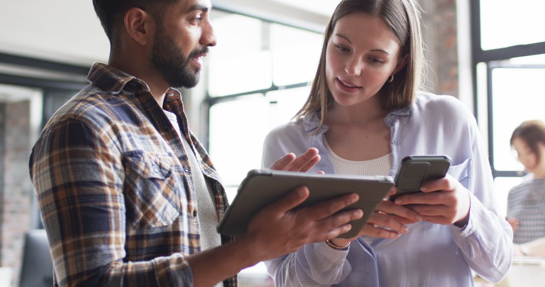 Diverse Coworkers Collaborating with Tablet and Smartphone