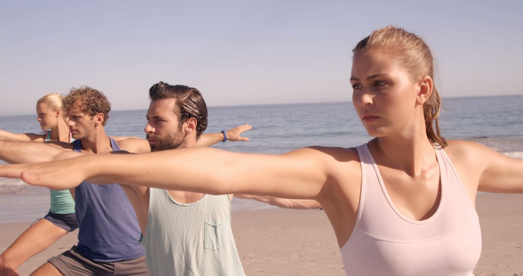 Group Practicing Yoga on Beach with Focused Expression - Free Images, Stock Photos and Pictures on Pikwizard.com