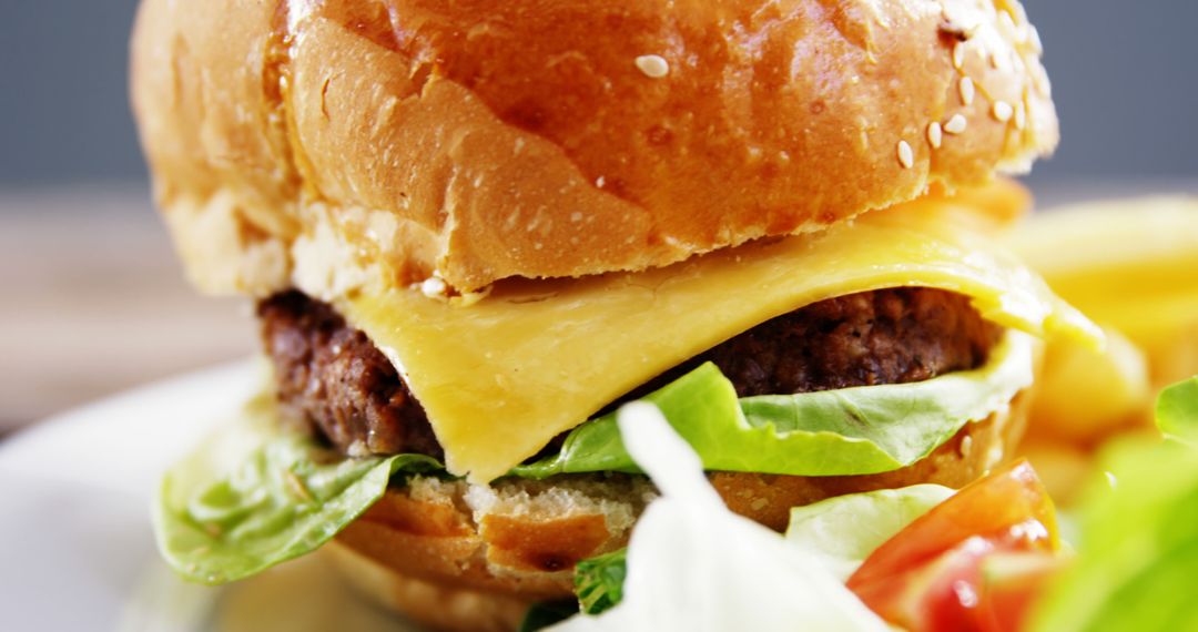 Close-up of a Juicy Cheeseburger with Lettuce and Tomato - Free Images, Stock Photos and Pictures on Pikwizard.com