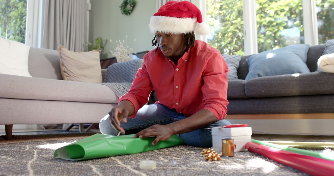 Man Wrapping Presents During Christmas Holiday Season at Home - Free Images, Stock Photos and Pictures on Pikwizard.com