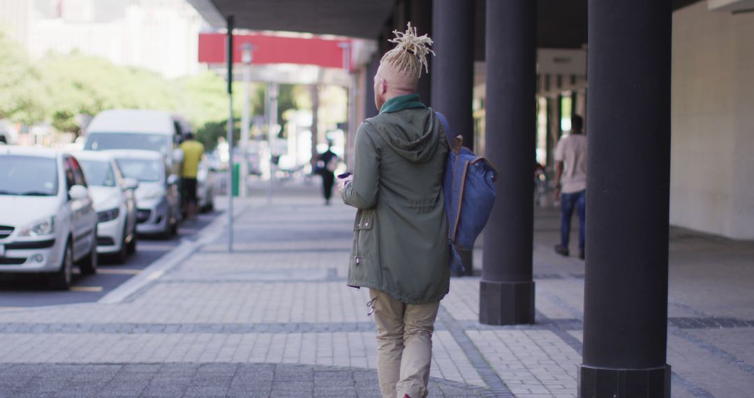 Albino African American Man Walking and Using Smartphone in Urban setting