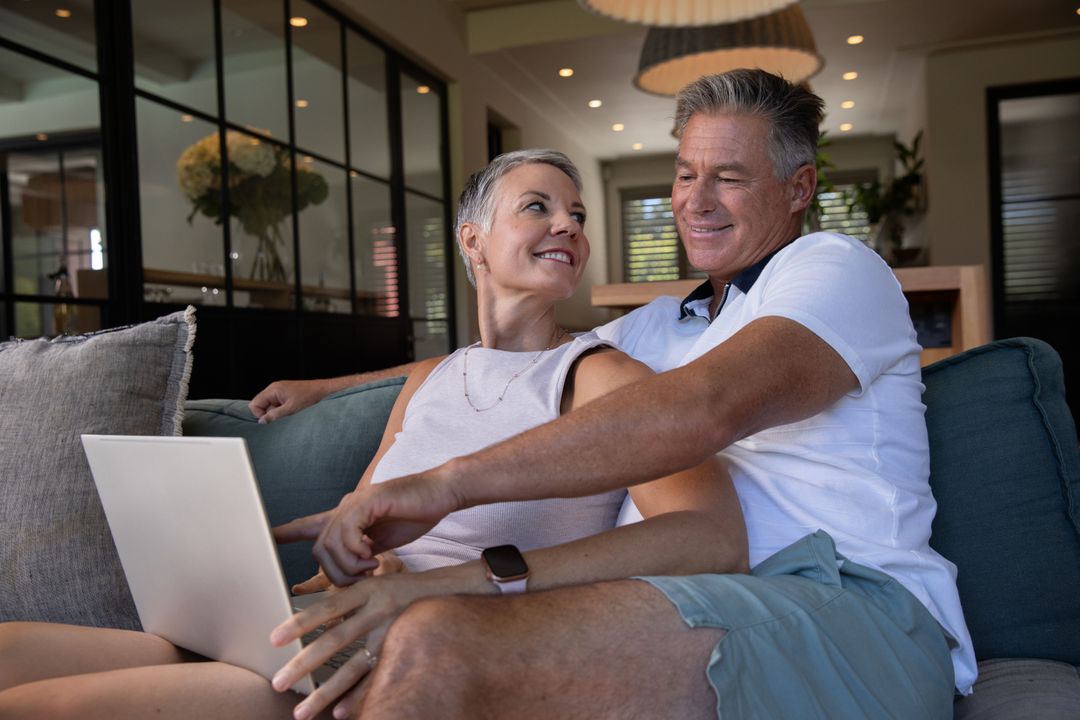 Senior Couple Enjoying Relaxed Laptop Browsing at Home