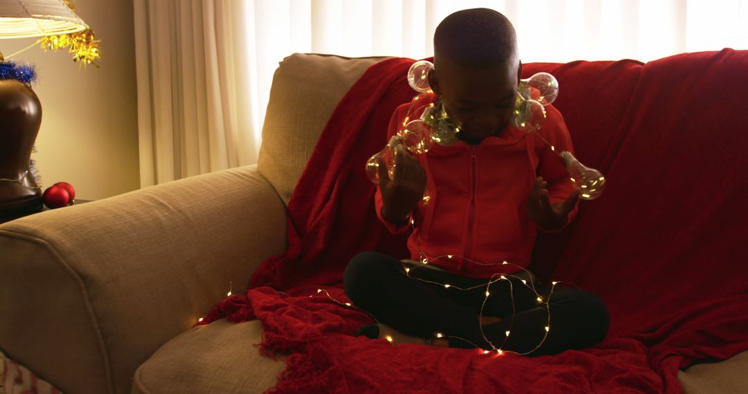 Child Sitting on Couch with String Lights - Free Images, Stock Photos and Pictures on Pikwizard.com