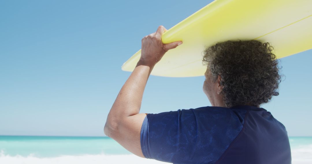 Senior Surfer Holding Surfboard On Sunny Beach - Free Images, Stock Photos and Pictures on Pikwizard.com