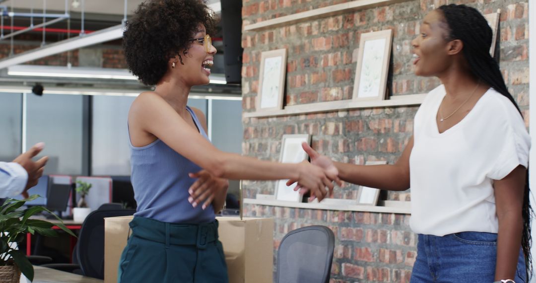 Colleagues Unpacking Box and Enjoying Laughter in Office