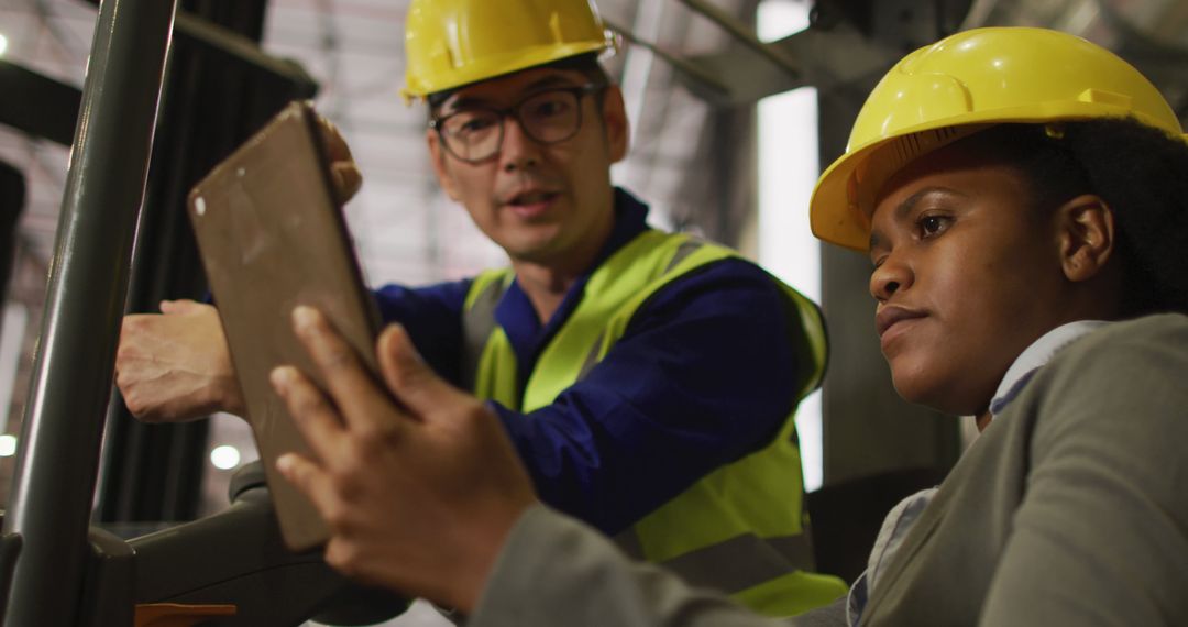 Engineers Wearing Safety Helmets Analyzing Data on Digital Tablet in Industrial Environment - Free Images, Stock Photos and Pictures on Pikwizard.com